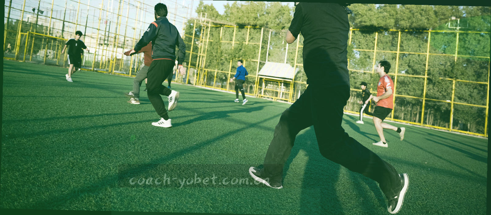 球场中线的俯拍局部，白色场线横贯画面，草皮纹理构成水平刻度感